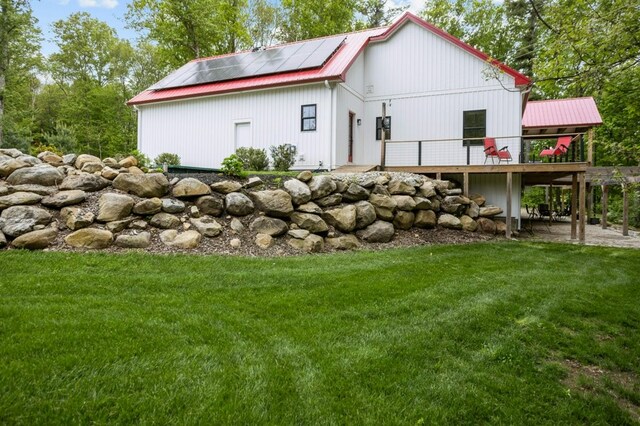 45 Lloyd Bowen Ct, Glocester, RI 02814 - back of house with a deck, a lawn, metal roof, and roof mounted solar panels