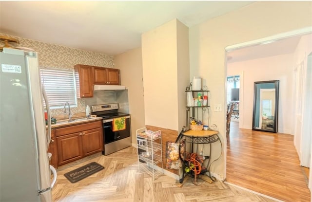 12 Hamilton St, Providence, RI 02907 - kitchen with freestanding refrigerator, stainless steel range with electric cooktop, under cabinet range hood, a sink, and brown cabinetry