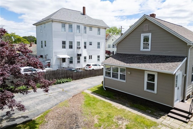 130 Hunts Ave, Pawtucket, RI 02861 - back of property with a shingled roof and a chimney