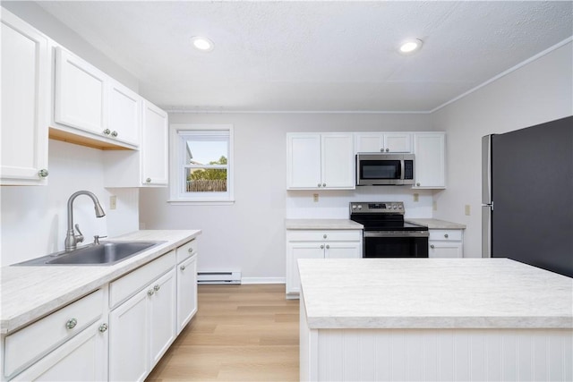 130 Hunts Ave, Pawtucket, RI 02861 - kitchen with stainless steel appliances, a sink, baseboard heating, light countertops, and light wood-style floors