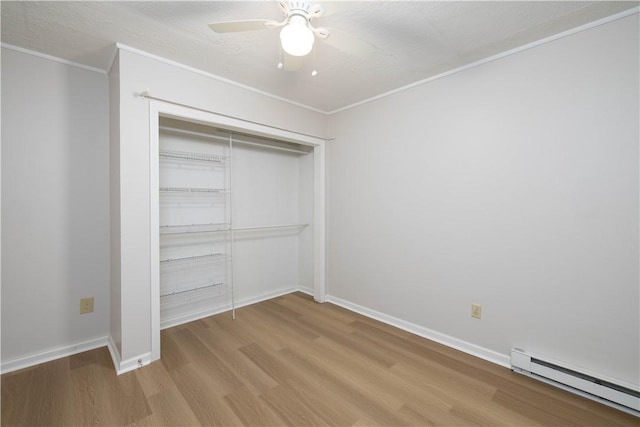 130 Hunts Ave, Pawtucket, RI 02861 - unfurnished bedroom featuring baseboard heating, wood finished floors, ornamental molding, a closet, and baseboards