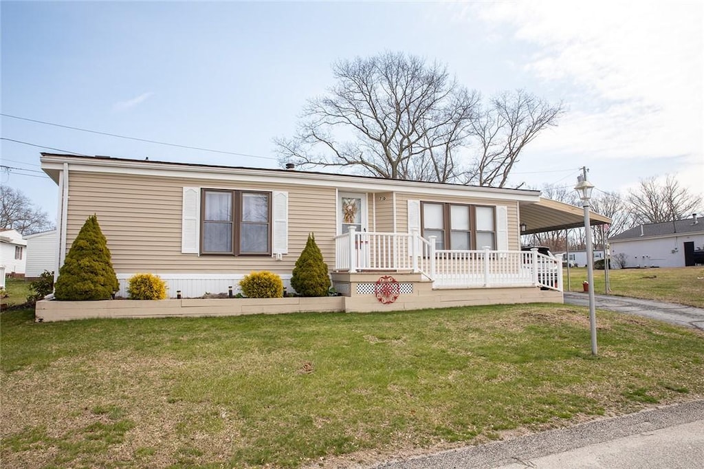 7 Lane D Dr, Coventry, RI 02816 - manufactured / mobile home featuring asphalt driveway, an attached carport, a front lawn, and covered porch