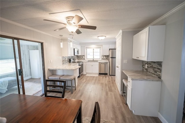 7 Lane D Dr, Coventry, RI 02816 - kitchen with stainless steel appliances, backsplash, white cabinetry, light countertops, and ornamental molding