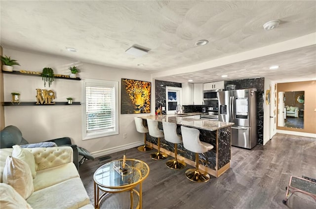 848 Dexter St, Central Falls, RI 02863 - kitchen featuring stainless steel appliances, baseboards, a peninsula, dark wood finished floors, and a breakfast bar