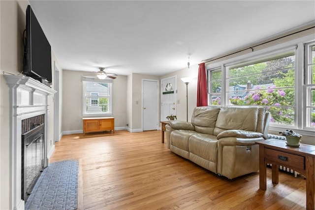199 Vaughn Ave, Warwick, RI 02886 - living area featuring light wood finished floors, a fireplace with flush hearth, a ceiling fan, and baseboards