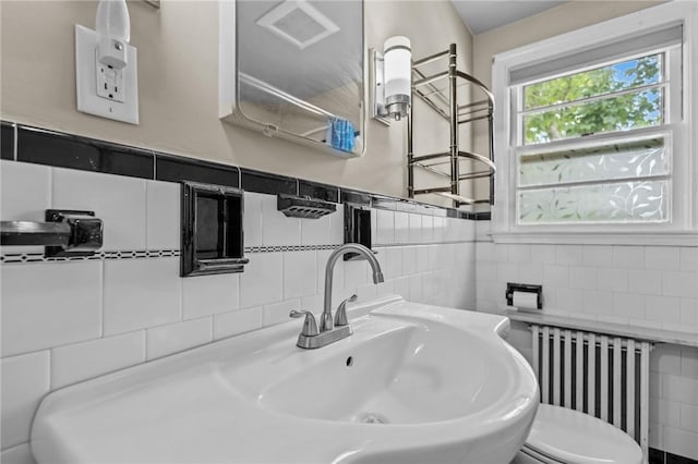 199 Vaughn Ave, Warwick, RI 02886 - bathroom featuring radiator heating unit, tile walls, a sink, toilet, and a wainscoted wall