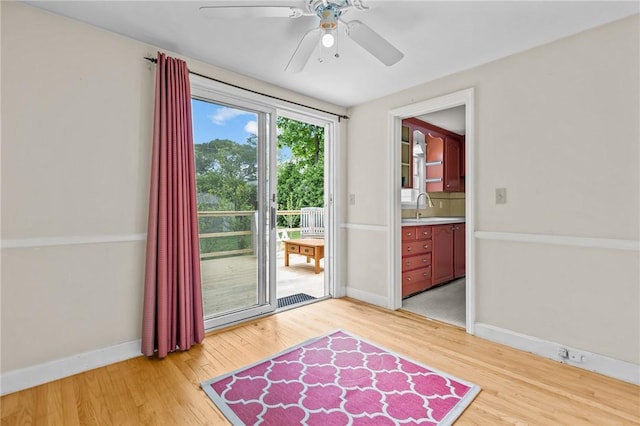 199 Vaughn Ave, Warwick, RI 02886 - doorway to outside featuring a sink, a ceiling fan, light wood-type flooring, and baseboards