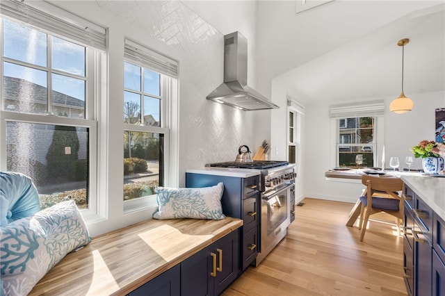 14 Robinson St, Narragansett, RI 02882 - kitchen featuring wall chimney exhaust hood, butcher block countertops, blue cabinets, high end stainless steel range oven, and light wood-style floors