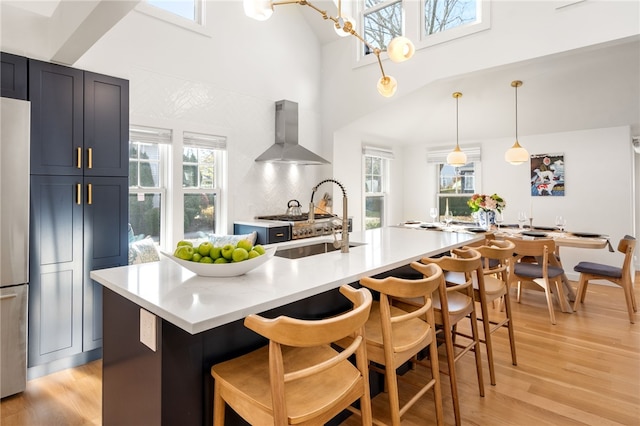 14 Robinson St, Narragansett, RI 02882 - kitchen with wall chimney exhaust hood, a sink, light wood finished floors, light countertops, and a towering ceiling