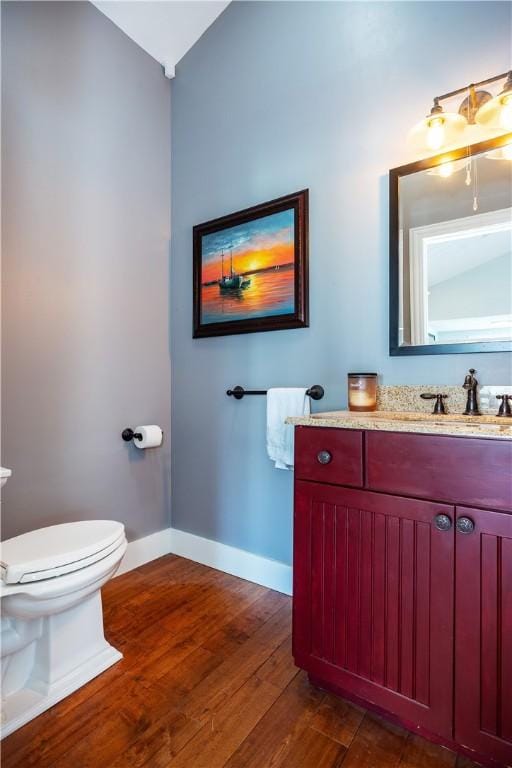 3976 Post Rd, Warwick, RI 02886 - bathroom with toilet, hardwood / wood-style floors, baseboards, vanity, and vaulted ceiling