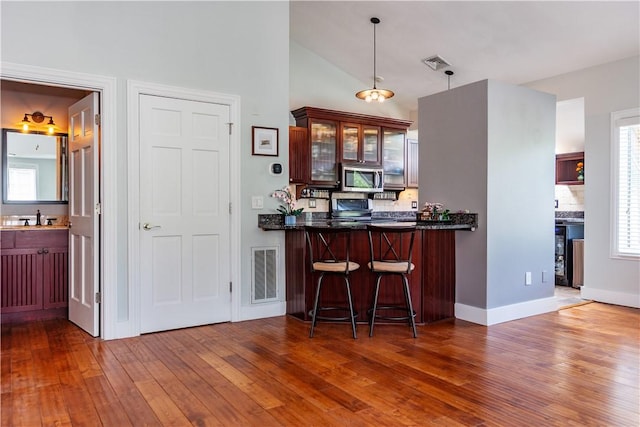 3976 Post Rd, Warwick, RI 02886 - bar featuring stainless steel appliances, hardwood / wood-style flooring, decorative light fixtures, a sink, and decorative backsplash