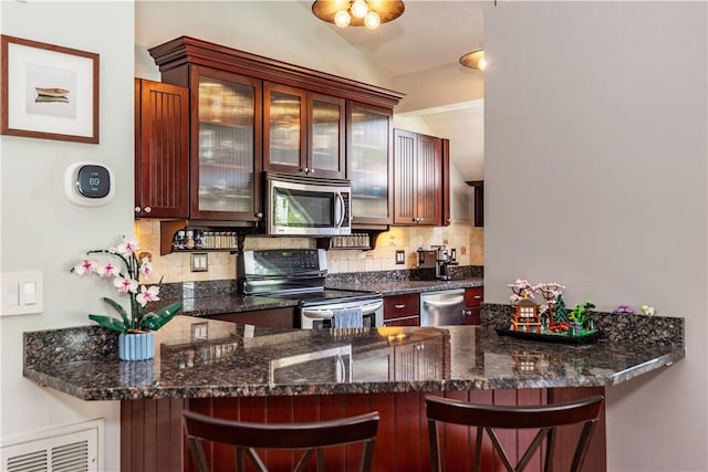 3976 Post Rd, Warwick, RI 02886 - kitchen featuring stainless steel appliances, a peninsula, tasteful backsplash, a breakfast bar area, and lofted ceiling