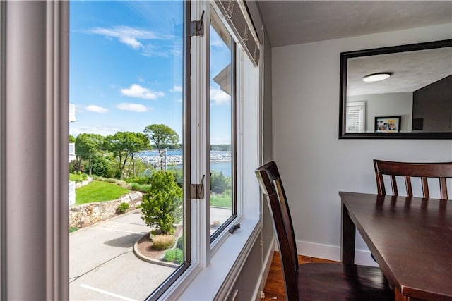 3976 Post Rd, Warwick, RI 02886 - dining area with dark wood finished floors, a water view, and baseboards