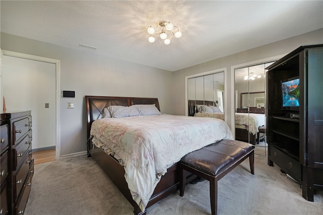29 Valley View Dr, Cranston, RI 02921 - bedroom featuring light carpet, multiple closets, a chandelier, and baseboards