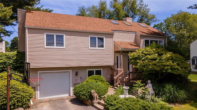 29 Valley View Dr, Cranston, RI 02921 - split level home featuring a chimney, a garage, asphalt driveway, a shingled roof, and a deck
