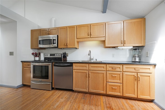 29 Valley View Dr, Cranston, RI 02921 - kitchen with stainless steel appliances, a sink, backsplash, light wood finished floors, and dark countertops