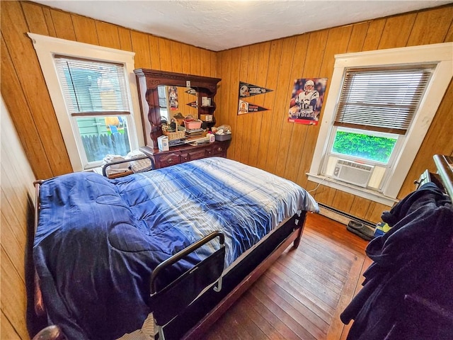 106 Baxter St, Pawtucket, RI 02861 - bedroom featuring wooden walls, wood-type flooring, cooling unit, and baseboard heating