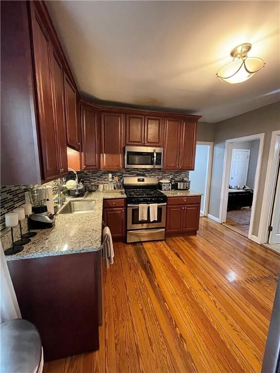 86 Edgemere Ave, Providence, RI 02909 - kitchen featuring stainless steel appliances, a sink, backsplash, and wood finished floors