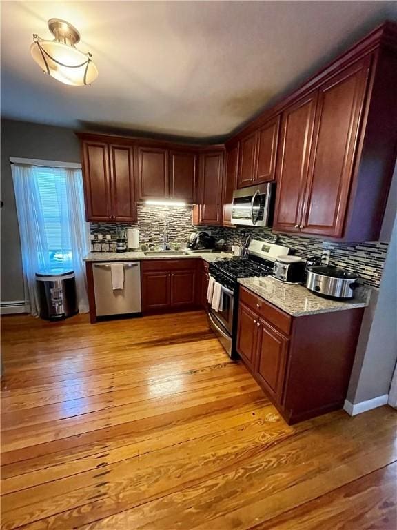 86 Edgemere Ave, Providence, RI 02909 - kitchen featuring stainless steel appliances, backsplash, light wood finished floors, and a sink
