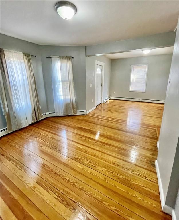 86 Edgemere Ave, Providence, RI 02909 - unfurnished room featuring wood-type flooring, a baseboard radiator, and healthy amount of natural light
