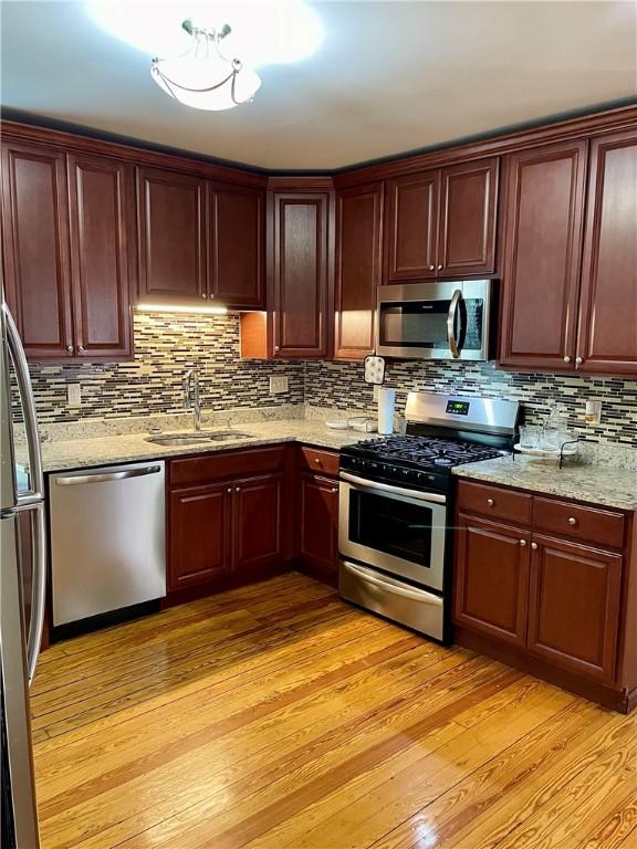 86 Edgemere Ave, Providence, RI 02909 - kitchen featuring stainless steel appliances, a sink, tasteful backsplash, light wood finished floors, and light stone counters