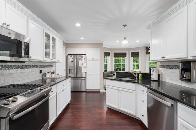 3 Berm Dr, Cumberland, RI 02864 - kitchen with stainless steel appliances, crown molding, a sink, white cabinetry, and decorative backsplash