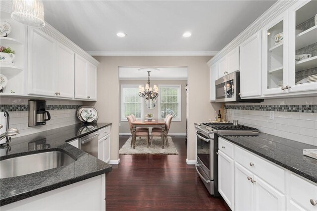 3 Berm Dr, Cumberland, RI 02864 - kitchen with appliances with stainless steel finishes, a chandelier, backsplash, white cabinets, and ornamental molding