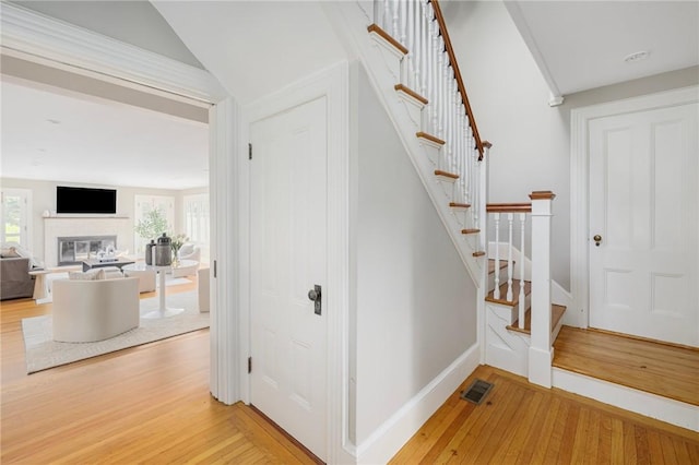 211 Rumstick Rd, Barrington, RI 02806 - stairway with hardwood / wood-style flooring, a glass covered fireplace, and vaulted ceiling