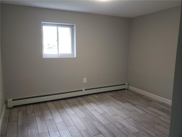 56 River St Unit 23, West Warwick, RI 02893 - empty room with a baseboard heating unit, wood finished floors, and baseboards