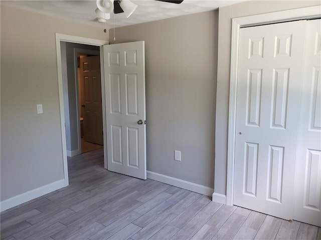 56 River St Unit 23, West Warwick, RI 02893 - unfurnished bedroom with light wood-type flooring, baseboards, a ceiling fan, and a closet