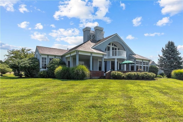 33 Courageous Cir, Bristol, RI 02809 - rear view of property with a balcony, a yard, a chimney, and brick siding
