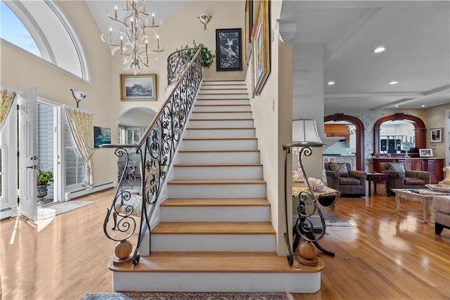 33 Courageous Cir, Bristol, RI 02809 - staircase with wood finished floors, arched walkways, recessed lighting, a chandelier, and a baseboard heating unit