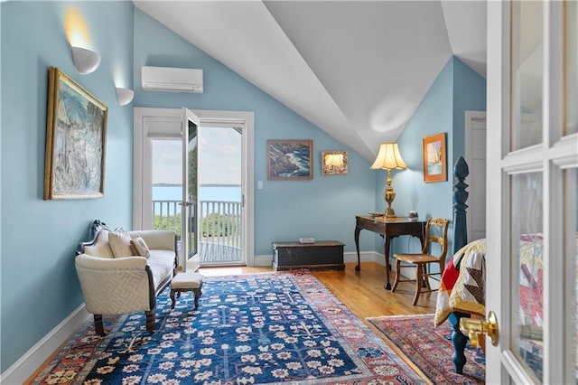 33 Courageous Cir, Bristol, RI 02809 - sitting room featuring a wall mounted AC, lofted ceiling, wood finished floors, and baseboards