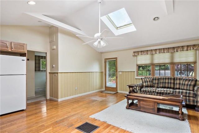 75 Circuit Dr, Narragansett, RI 02882 - living area with a wainscoted wall, a skylight, light wood-style floors, a ceiling fan, and high vaulted ceiling