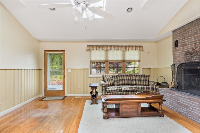 75 Circuit Dr, Narragansett, RI 02882 - living room featuring vaulted ceiling, wainscoting, wood finished floors, a brick fireplace, and ceiling fan