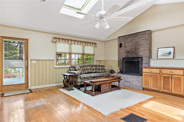 75 Circuit Dr, Narragansett, RI 02882 - living area with light wood-style flooring, a fireplace, healthy amount of natural light, a wainscoted wall, and high vaulted ceiling
