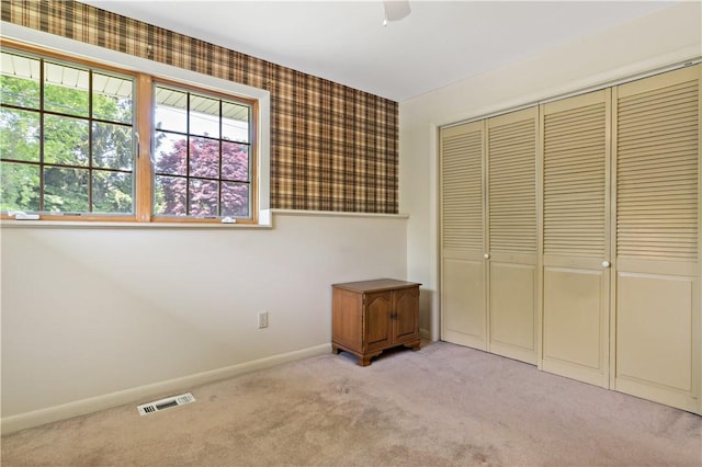 75 Circuit Dr, Narragansett, RI 02882 - unfurnished bedroom featuring light carpet, a closet, baseboards, multiple windows, and wallpapered walls