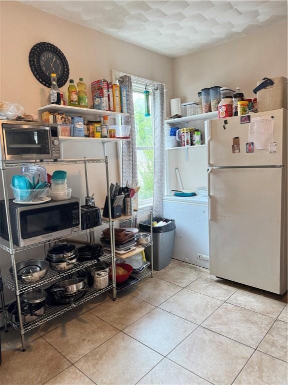 143 Mineral Spring Ave, Pawtucket, RI 02860 - kitchen with freestanding refrigerator, stainless steel microwave, tile patterned floors, and open shelves