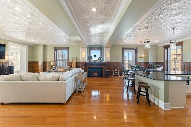 423 Hope St Unit C, Bristol, RI 02809 - living area featuring a wainscoted wall, light wood finished floors, crown molding, and a warm lit fireplace