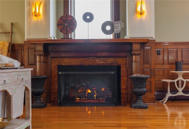 423 Hope St Unit C, Bristol, RI 02809 - detailed view of a lit fireplace, wood finished floors, and a baseboard heating unit