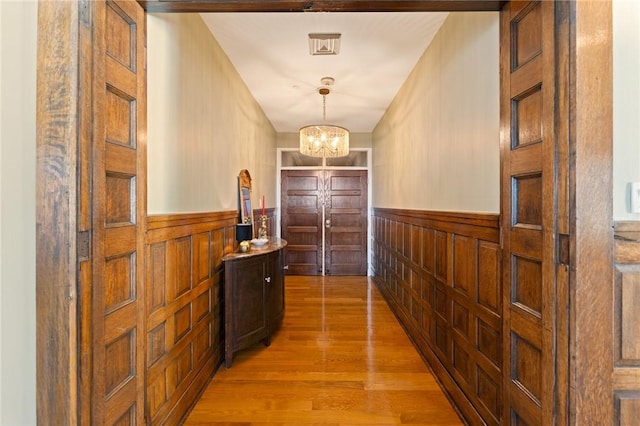 423 Hope St Unit C, Bristol, RI 02809 - corridor with a wainscoted wall, light wood finished floors, a chandelier, and wooden walls