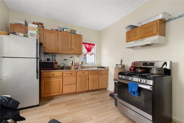 9 Sackett St, Providence, RI 02907 - kitchen with freestanding refrigerator, gas range, under cabinet range hood, light wood-style flooring, and a sink