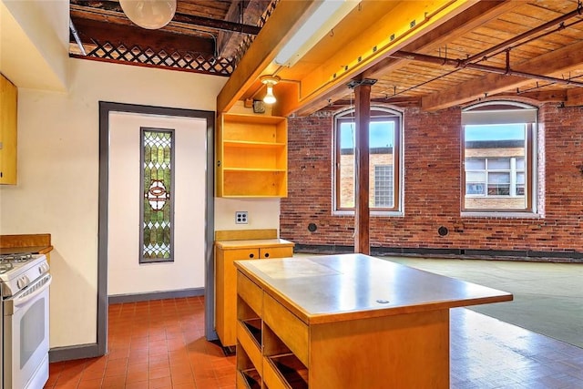 116 Chestnut St Unit G, Providence, RI 02903 - kitchen with white gas stove, plenty of natural light, baseboards, open shelves, and brick wall