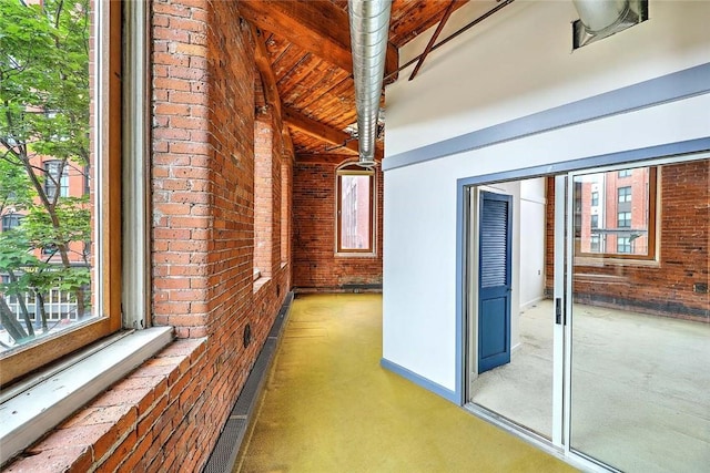 116 Chestnut St Unit G, Providence, RI 02903 - corridor featuring brick wall, healthy amount of natural light, carpet floors, baseboards, and beamed ceiling