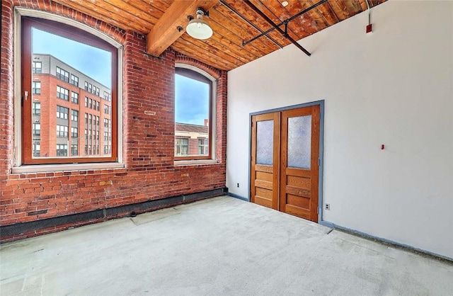 116 Chestnut St Unit G, Providence, RI 02903 - spare room with wood ceiling with exposed beams, healthy amount of natural light, brick wall, carpet flooring, and a high ceiling