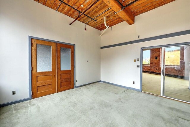 116 Chestnut St Unit G, Providence, RI 02903 - unfurnished room featuring wood ceiling with exposed beams, light colored carpet, baseboards, and a towering ceiling
