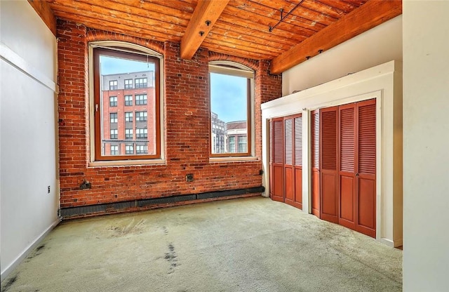 116 Chestnut St Unit G, Providence, RI 02903 - unfurnished bedroom with wood ceiling with exposed beams, carpet flooring, brick wall, multiple closets, and baseboards