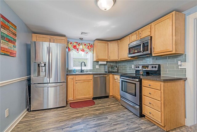 205 Carolyn St, Warwick, RI 02886 - kitchen featuring stainless steel appliances, dark countertops, light brown cabinets, and backsplash