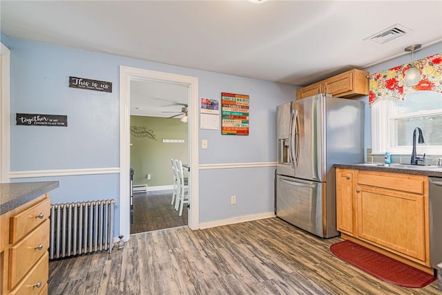 205 Carolyn St, Warwick, RI 02886 - kitchen with radiator, stainless steel appliances, dark countertops, and dark wood-style flooring