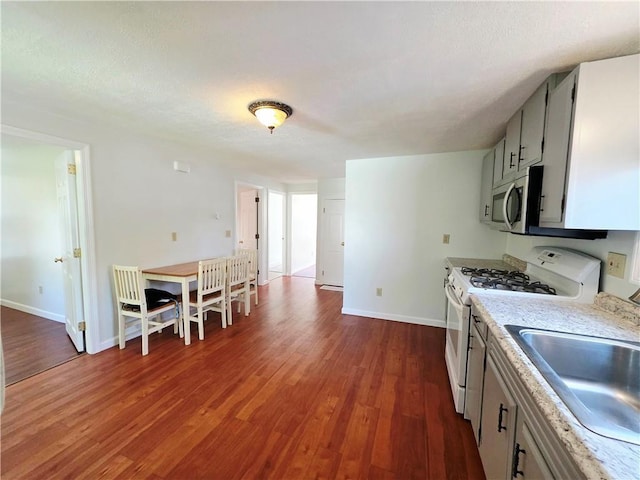 5 Rosemont Ter, North Providence, RI 02911 - kitchen with white gas range, stainless steel microwave, dark wood-type flooring, and light countertops